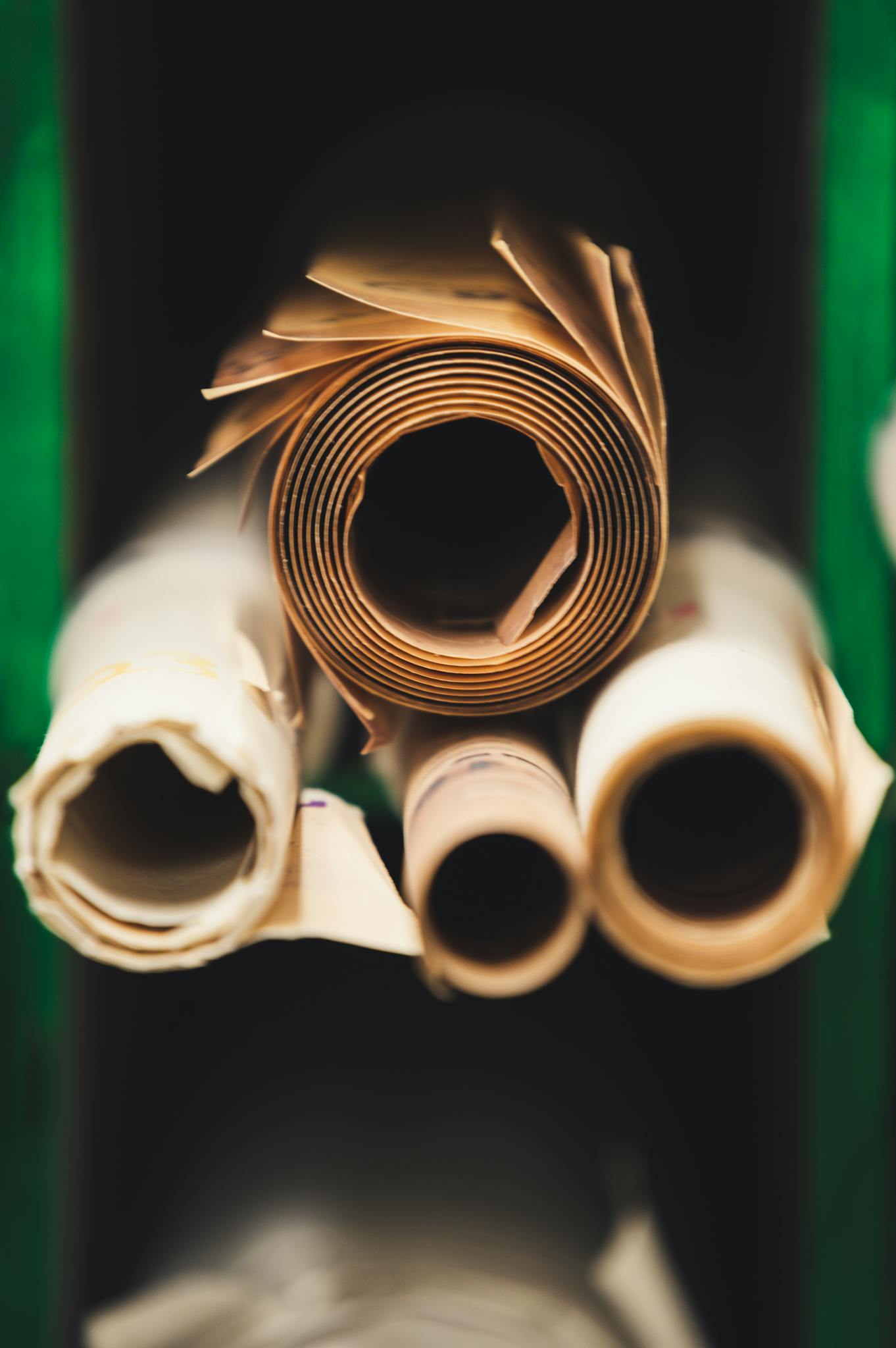 Rolled paper sheets stacked in a workshop setting, showcasing craftsmanship and industry.