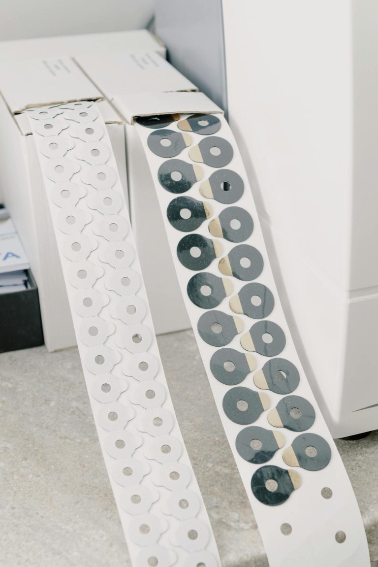 White cardboard boxes with adhesive tape with anti slip pads for hydrophobic optical lenses placed on marble surface in workspace